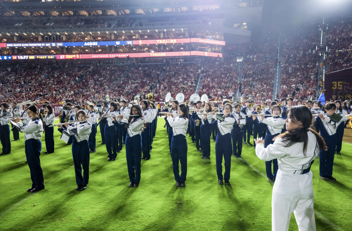 COLLEGE LEVEL CHOREOGRAPHY: Drum major senior Erica Zou helps conduct the Northwood marching band during their performance at the USC football game’s halftime show.